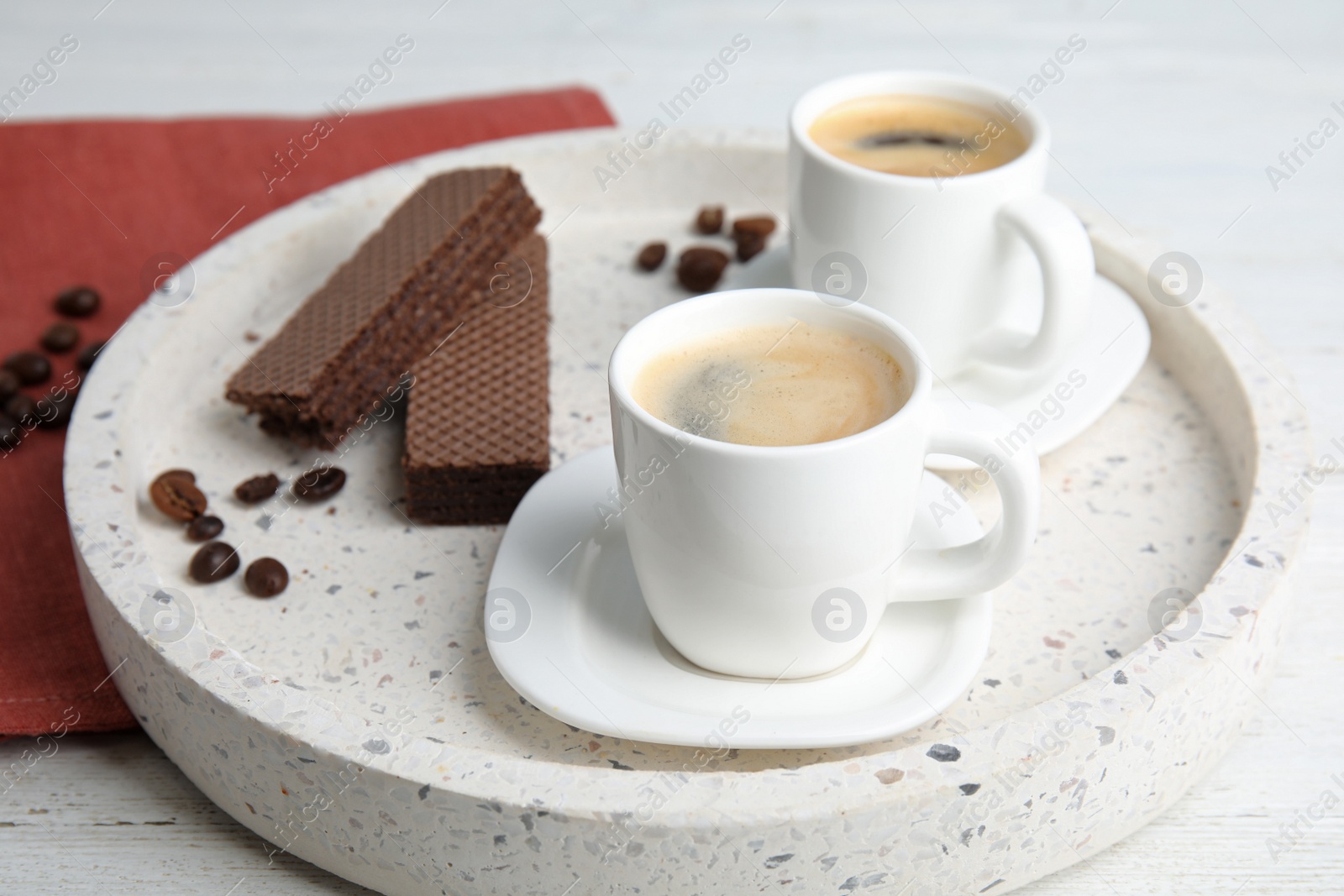 Photo of Delicious coffee and wafers for breakfast on white wooden table