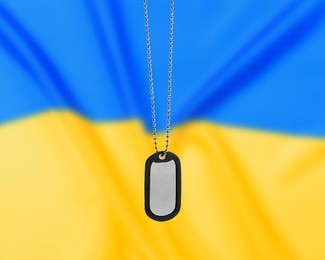Military ID tag and Ukrainian flag on background