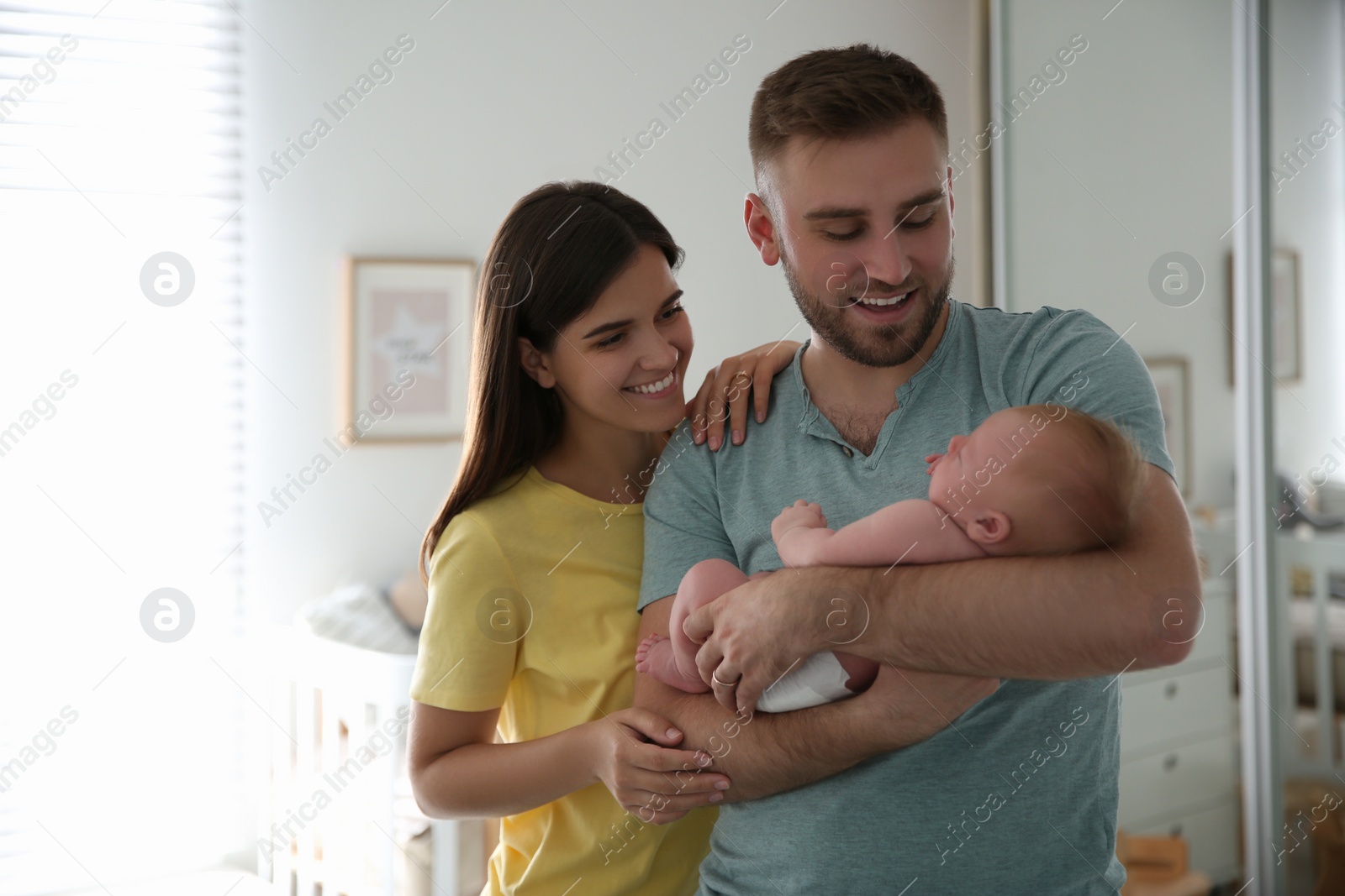 Photo of Happy couple with their newborn baby at home