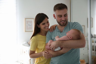 Happy couple with their newborn baby at home