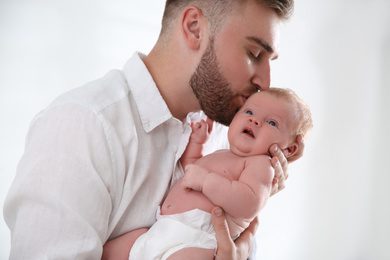 Photo of Father with his newborn son on light background, closeup