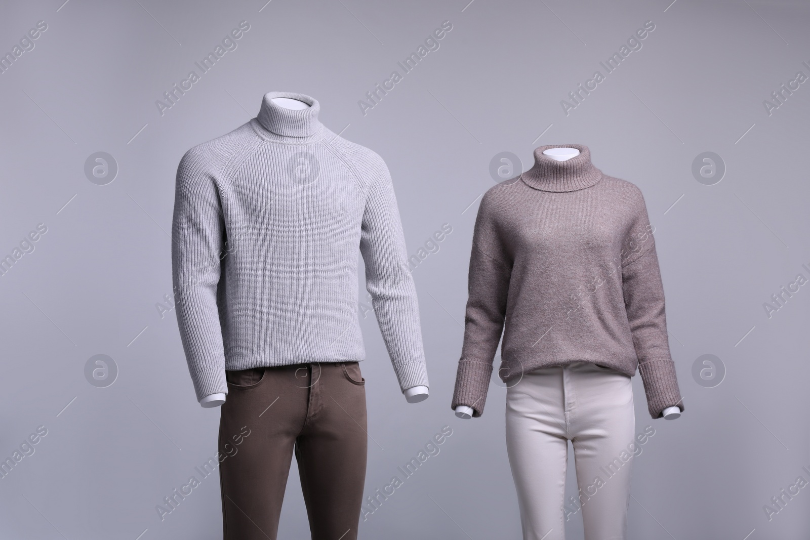 Photo of Male and female mannequins dressed in stylish outfits on grey background