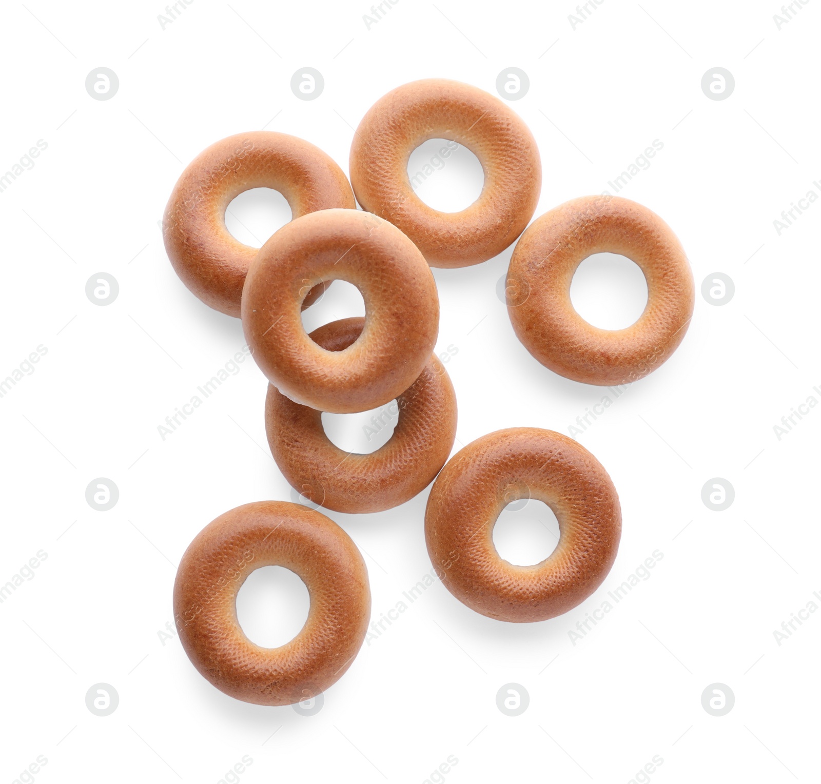 Photo of Many tasty dry bagels (sushki) isolated on white, top view