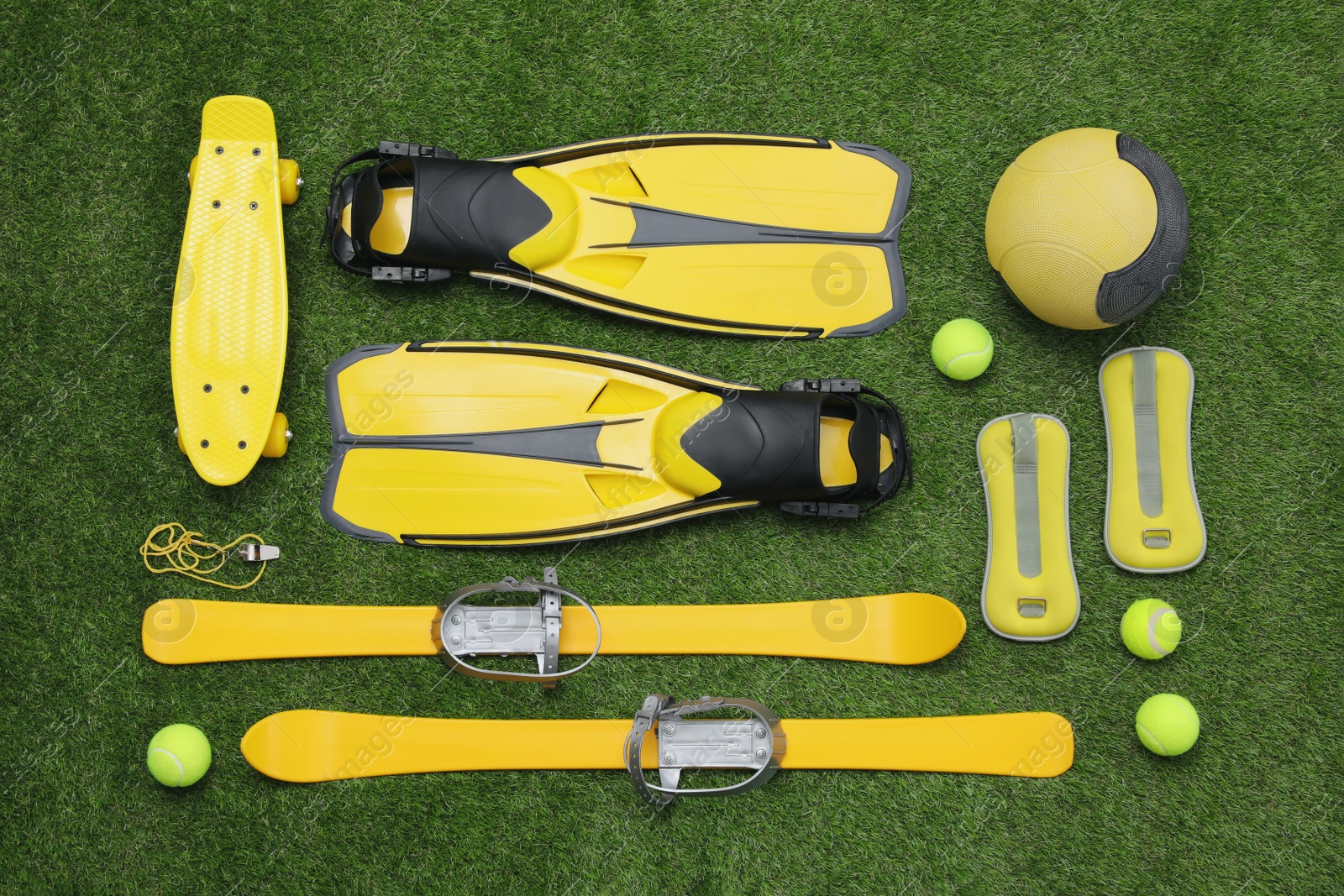 Photo of Different sport equipment on green grass, flat lay