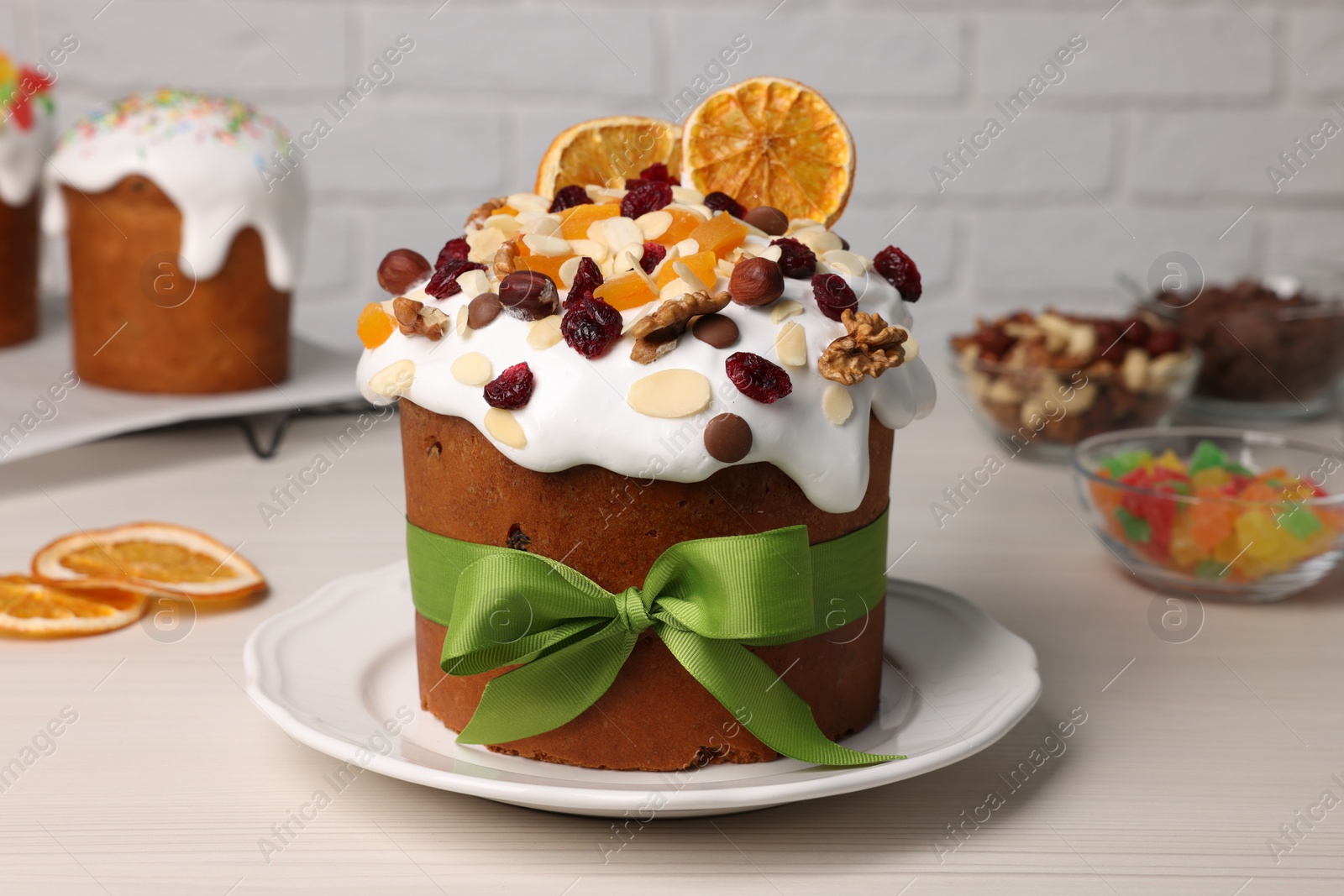 Photo of Tasty Easter cakes with dried fruits and nuts on white wooden table