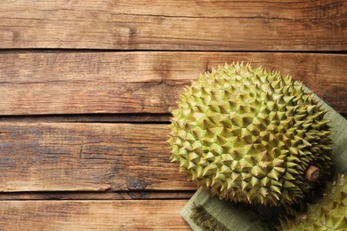 Ripe durians on wooden table, flat lay. Space for text