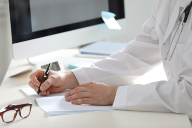 Photo of Doctor working at desk in office, closeup