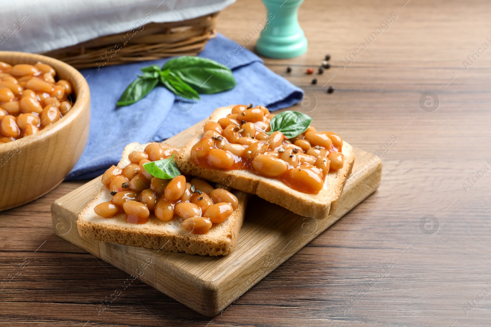 Photo of Toasts with delicious canned beans on wooden table