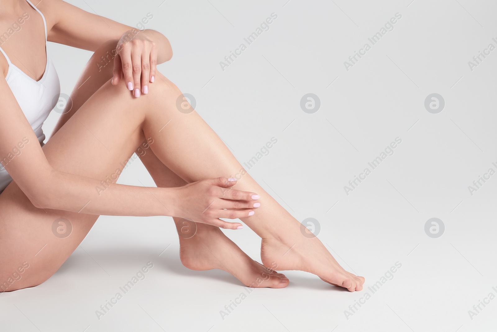 Photo of Woman with beautiful smooth legs on white background, closeup. Space for text