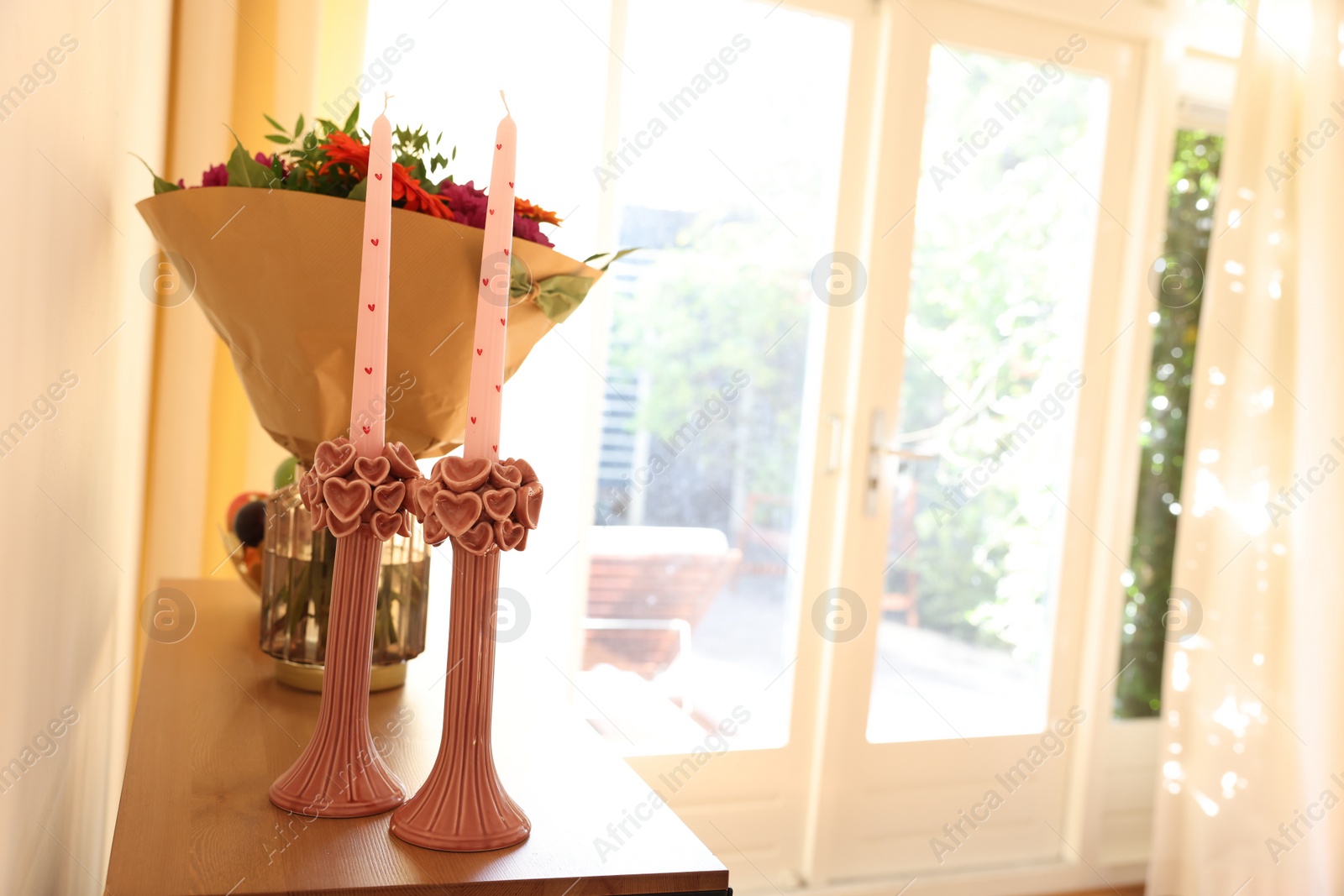 Photo of Bouquet of flowers and candles on wooden table indoors. Space for text