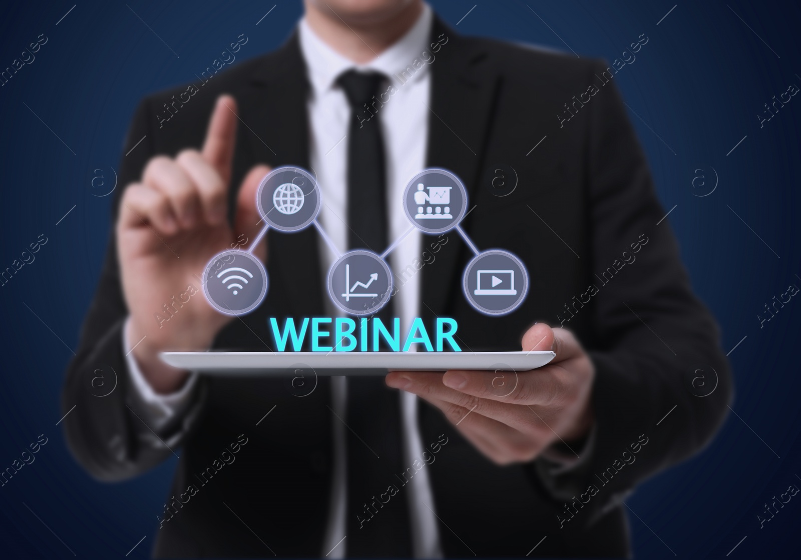 Image of Webinar. Man holding tablet on dark blue background, closeup. Virtual screen with icons over computer