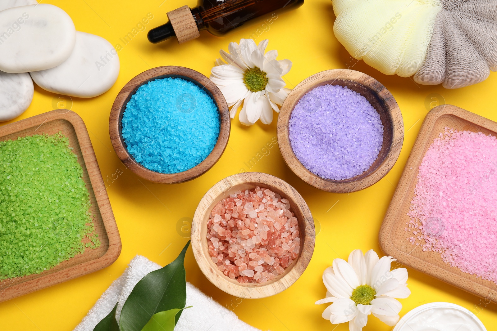 Photo of Flat lay composition with different sea salt on yellow background