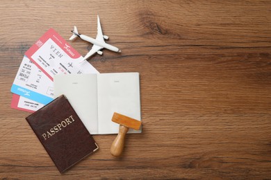 Photo of Flat lay composition with passports, stamp and flight tickets on wooden table, space for text