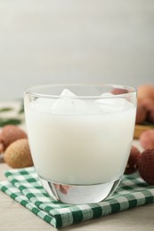 Photo of Fresh lychee juice on white wooden table, closeup