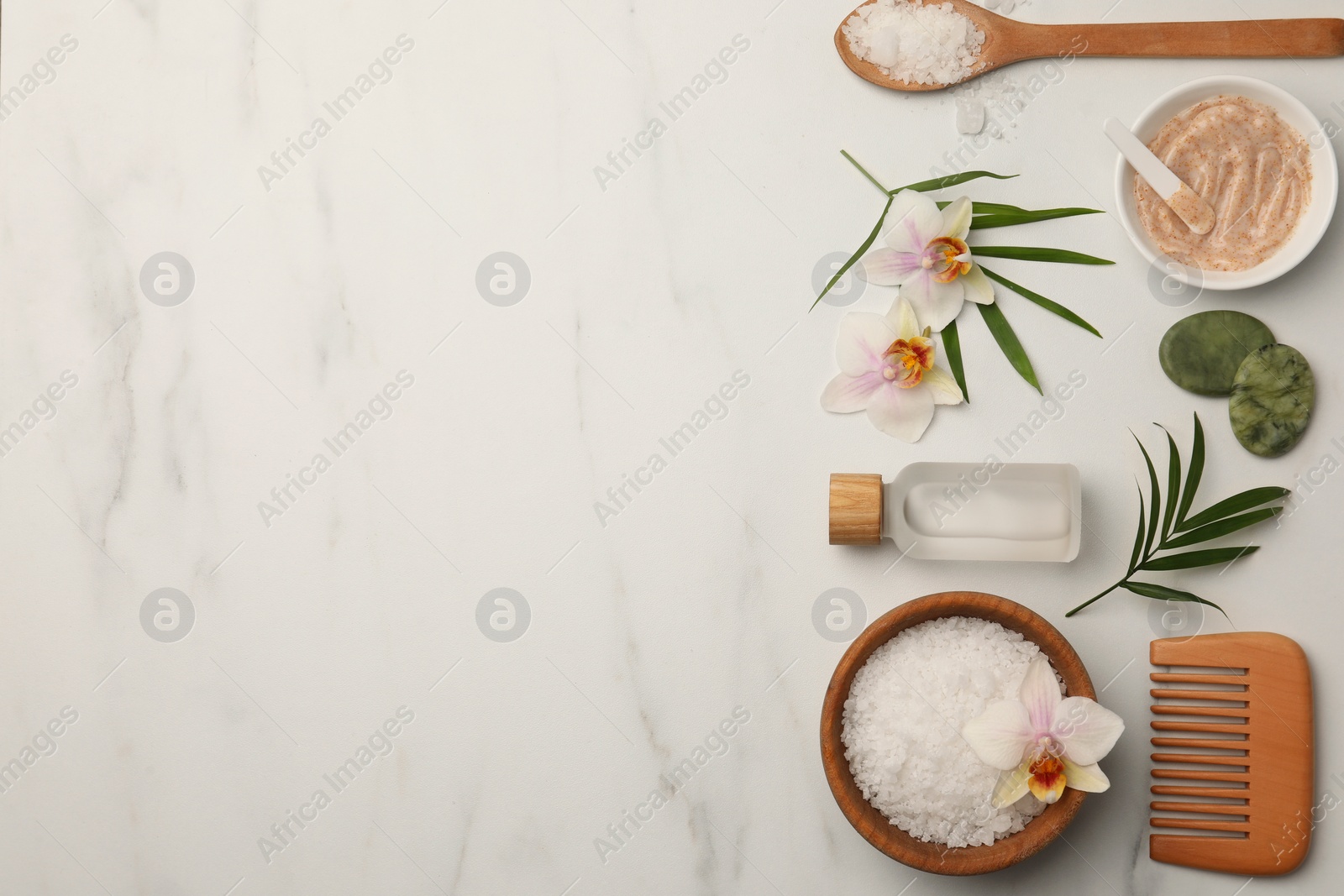 Photo of Flat lay composition with different spa products and flowers on white marble table. Space for text