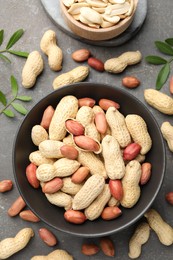 Fresh peanuts and twigs on grey table, flat lay