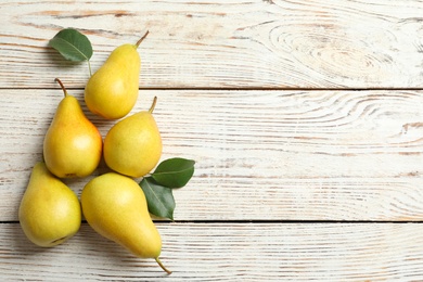 Photo of Flat lay composition with ripe pears on white wooden background. Space for text