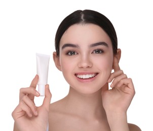 Teenage girl holding tube of foundation on white background