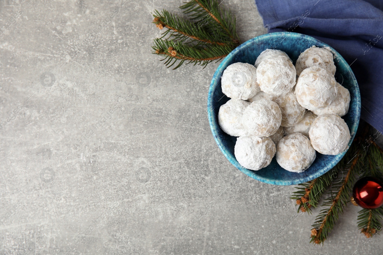 Photo of Flat lay composition with Christmas snowball cookies on grey table, space for text
