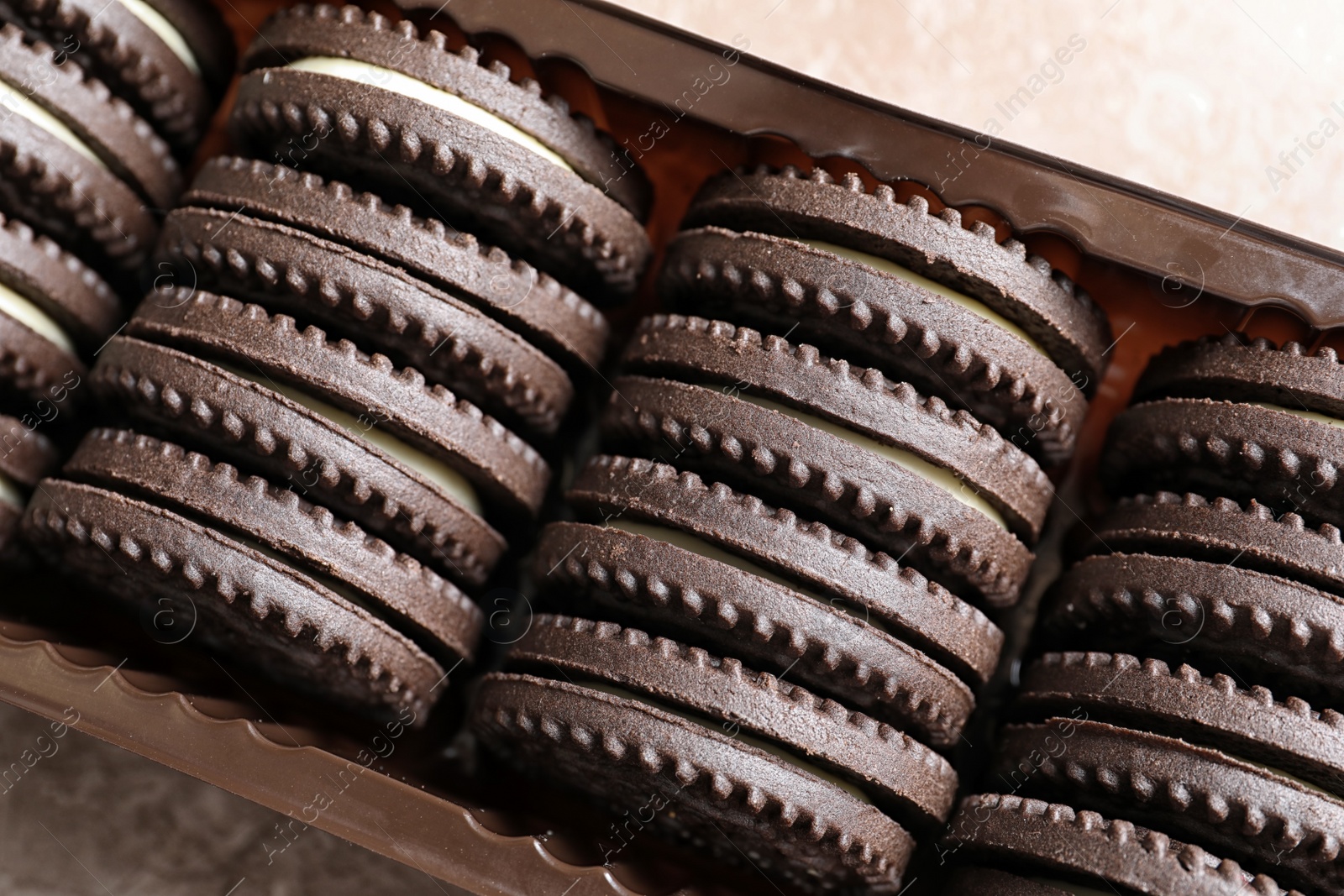 Photo of Box with chocolate and cream cookies, top view