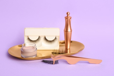 Photo of Magnetic eyelashes and accessories on violet background
