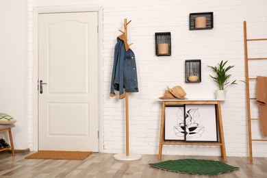 Photo of Stylish hallway interior with hanger stand and table