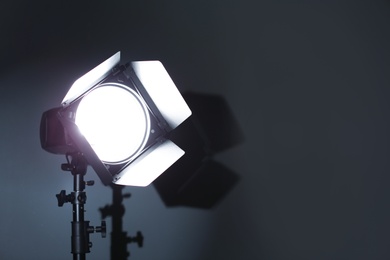 Photo of Professional photo studio lighting equipment on dark background. Space for text