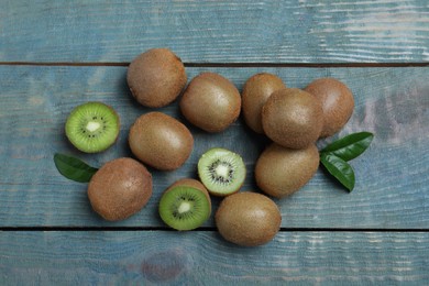 Photo of Fresh ripe kiwis on light blue wooden table, flat lay