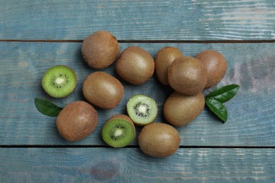 Fresh ripe kiwis on light blue wooden table, flat lay