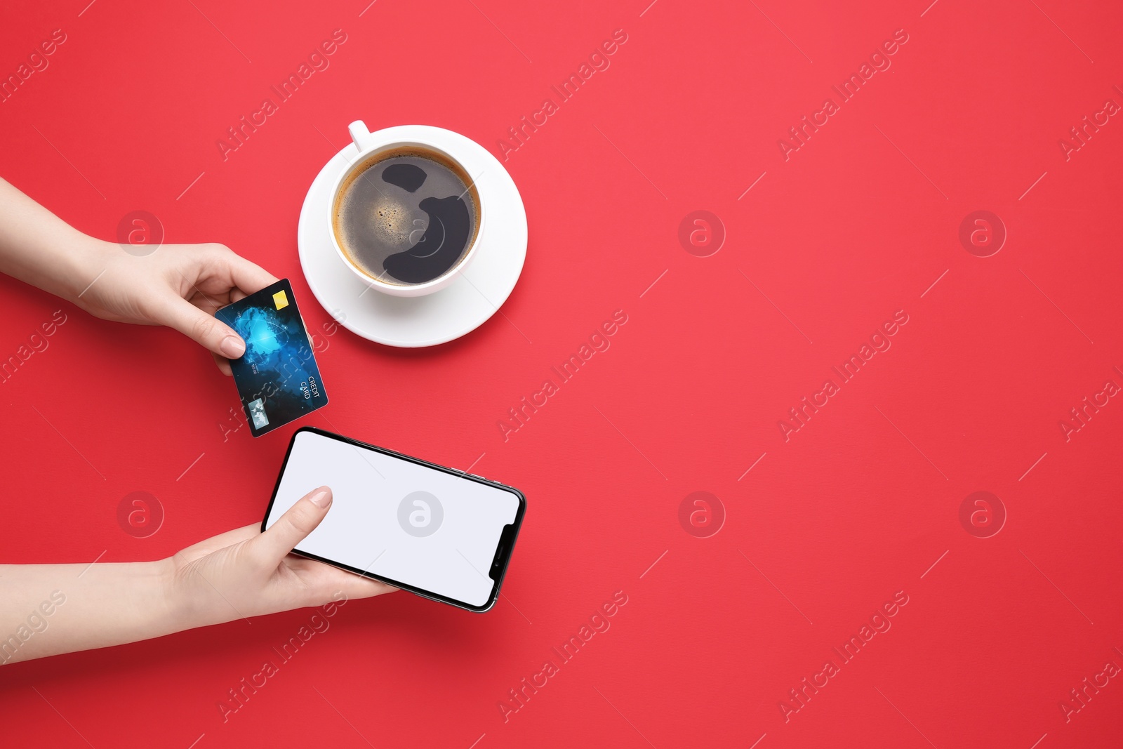 Photo of Online payment. Woman with smartphone, credit card and coffee on red background, top view. Space for text