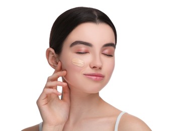 Teenage girl with swatch of foundation on face against white background
