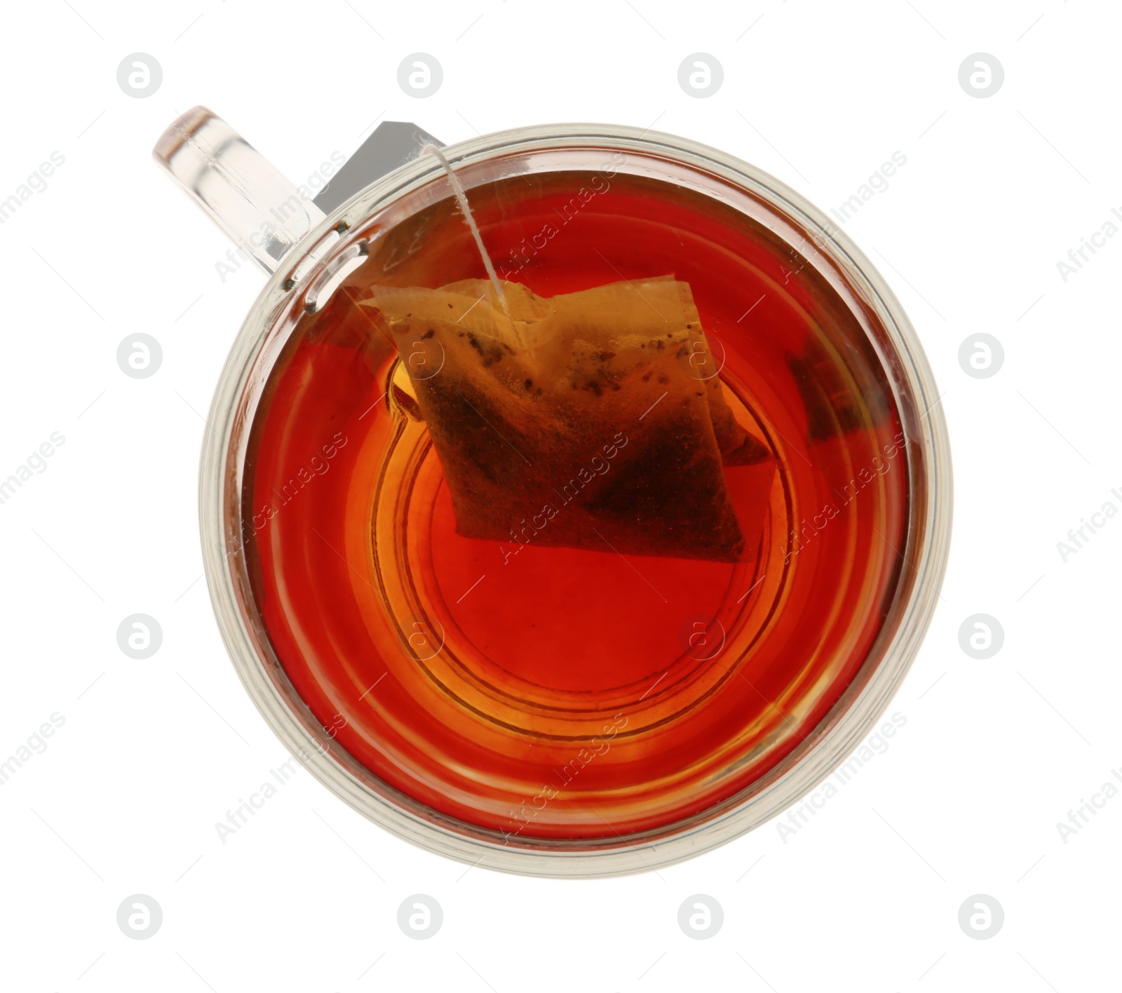 Photo of Tea bag in glass cup of hot water isolated on white, top view