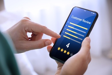 Image of Man using smartphone to give feedback indoors, closeup. Customer review