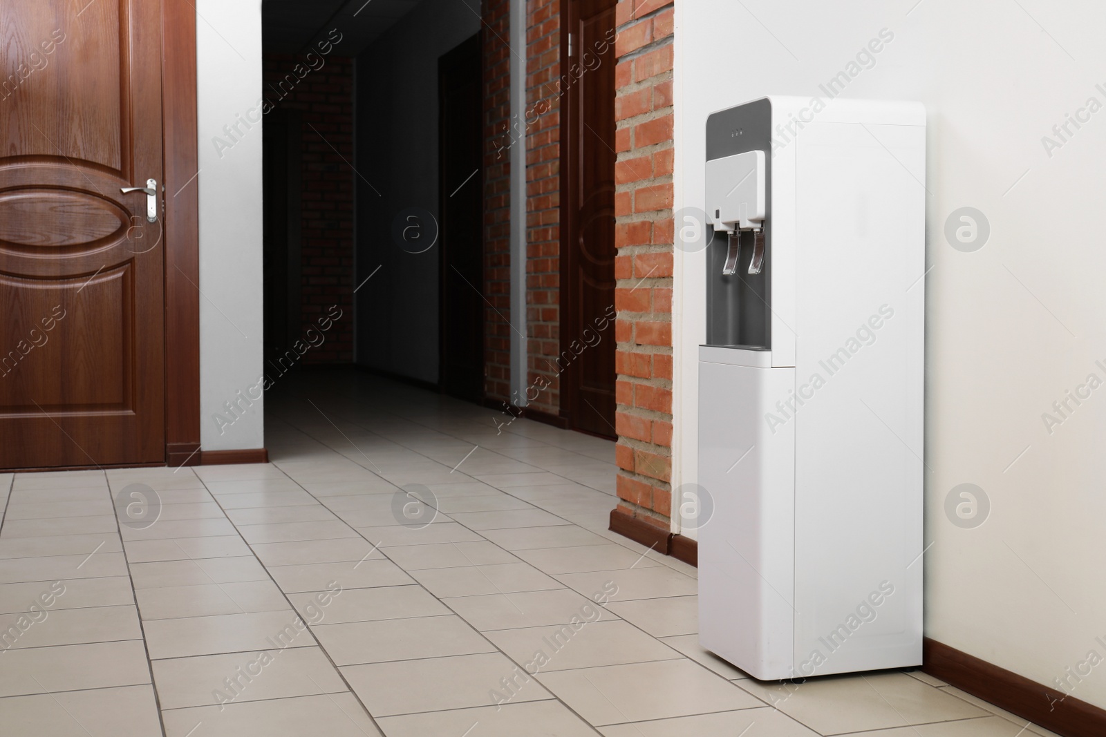 Photo of Modern water cooler in office hall