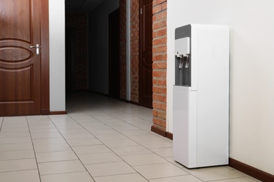 Photo of Modern water cooler in office hall