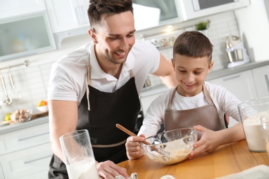 Dad and son cooking together in kitchen