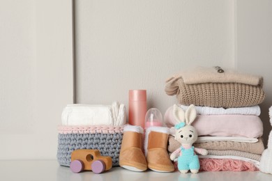 Baby clothes, toys and accessories on white table