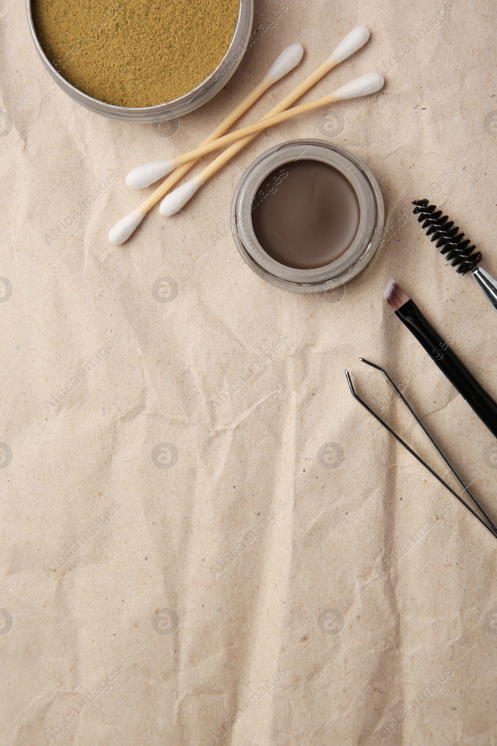 Photo of Flat lay composition with eyebrow henna and tools on crumpled paper. Space for text