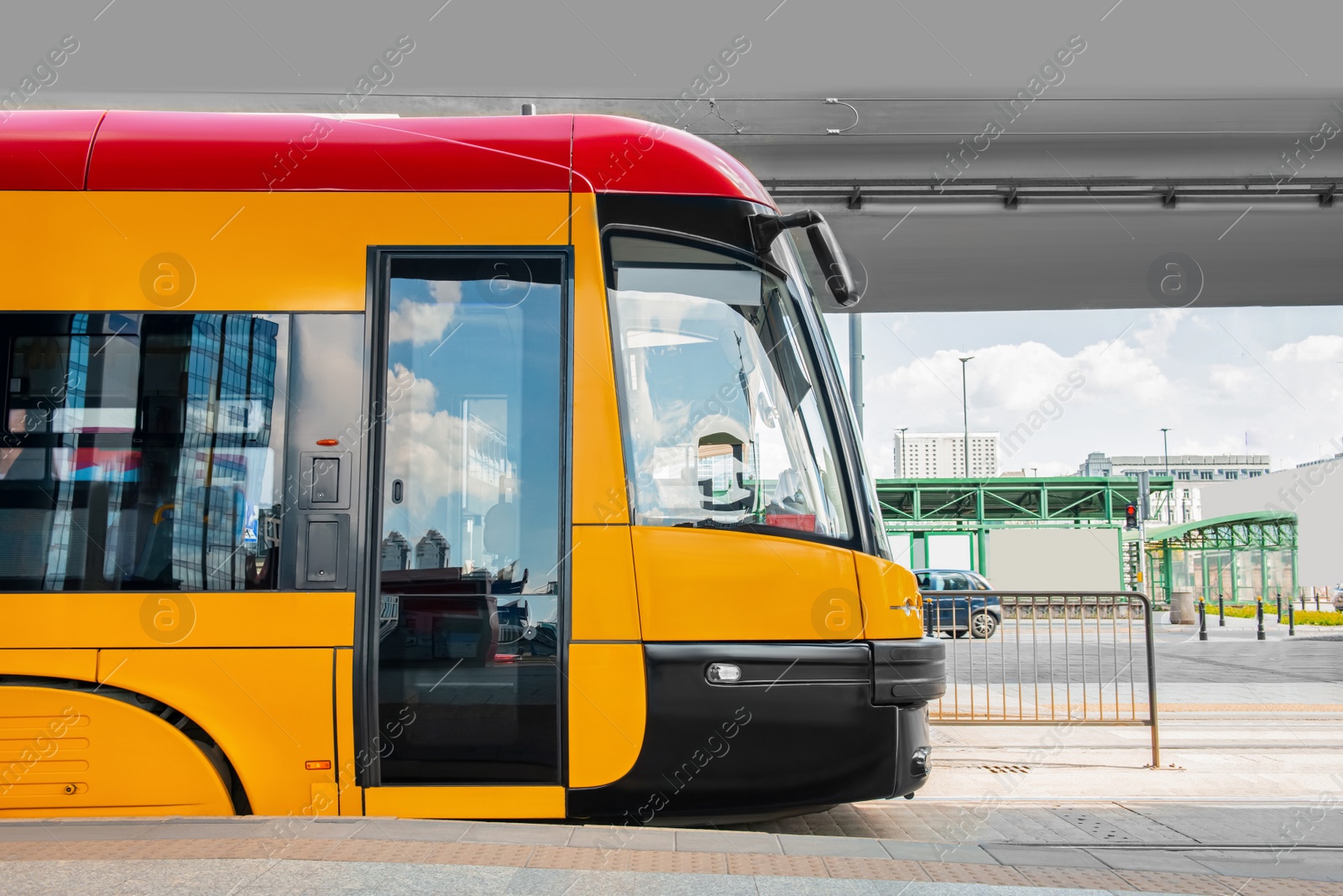 Photo of Modern streetcar near tram stop on sunny day. Public transport