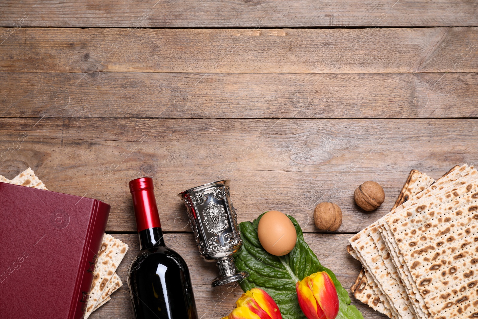 Photo of Flat lay composition with symbolic Pesach (Passover Seder) items on wooden table, space for text