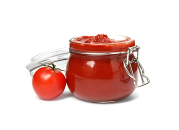 Photo of Tasty homemade tomato sauce in glass jar and fresh vegetable on white background