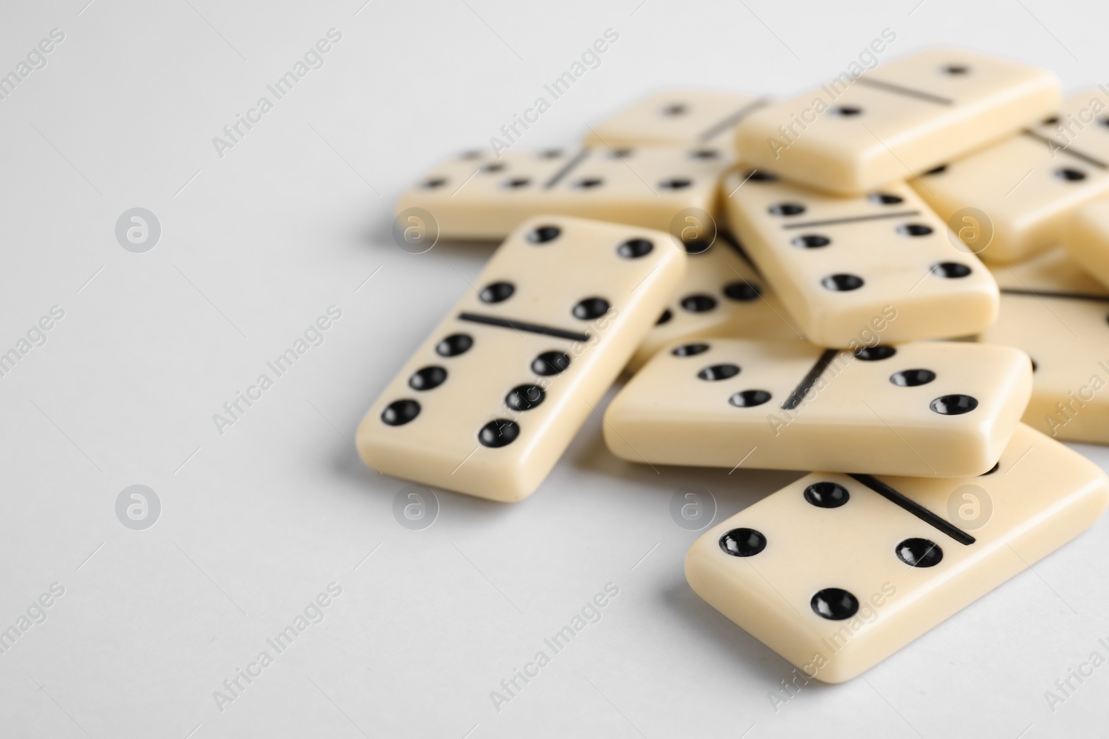 Photo of Domino tiles on white background. Space for text