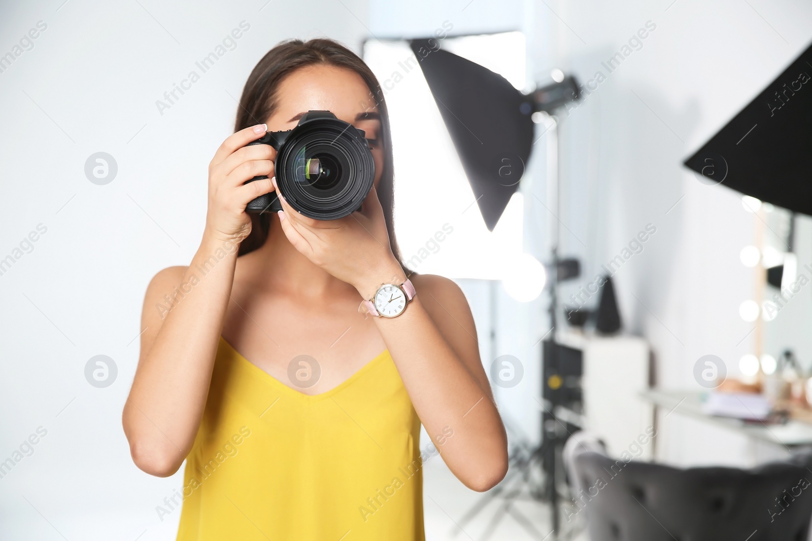 Photo of Professional photographer with camera in photo studio