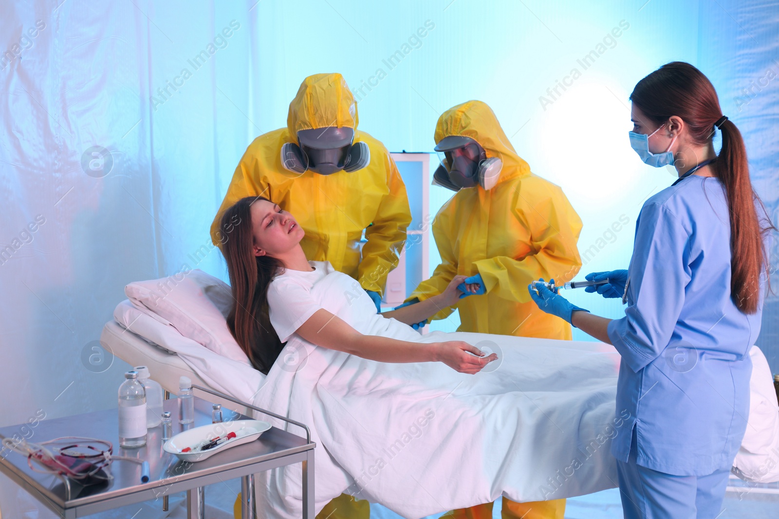 Photo of Professional paramedics examining patient with virus in quarantine ward