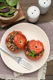 Photo of Delicious stuffed tomatoes with minced beef, bulgur and mushrooms served on wooden table, flat lay