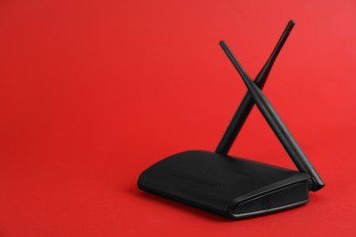 Modern Wi-Fi router on red background. Space for text