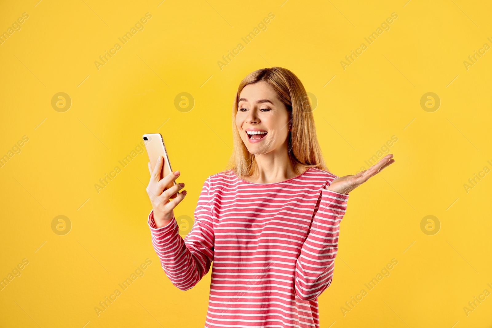 Photo of Woman using mobile phone for video chat on color background