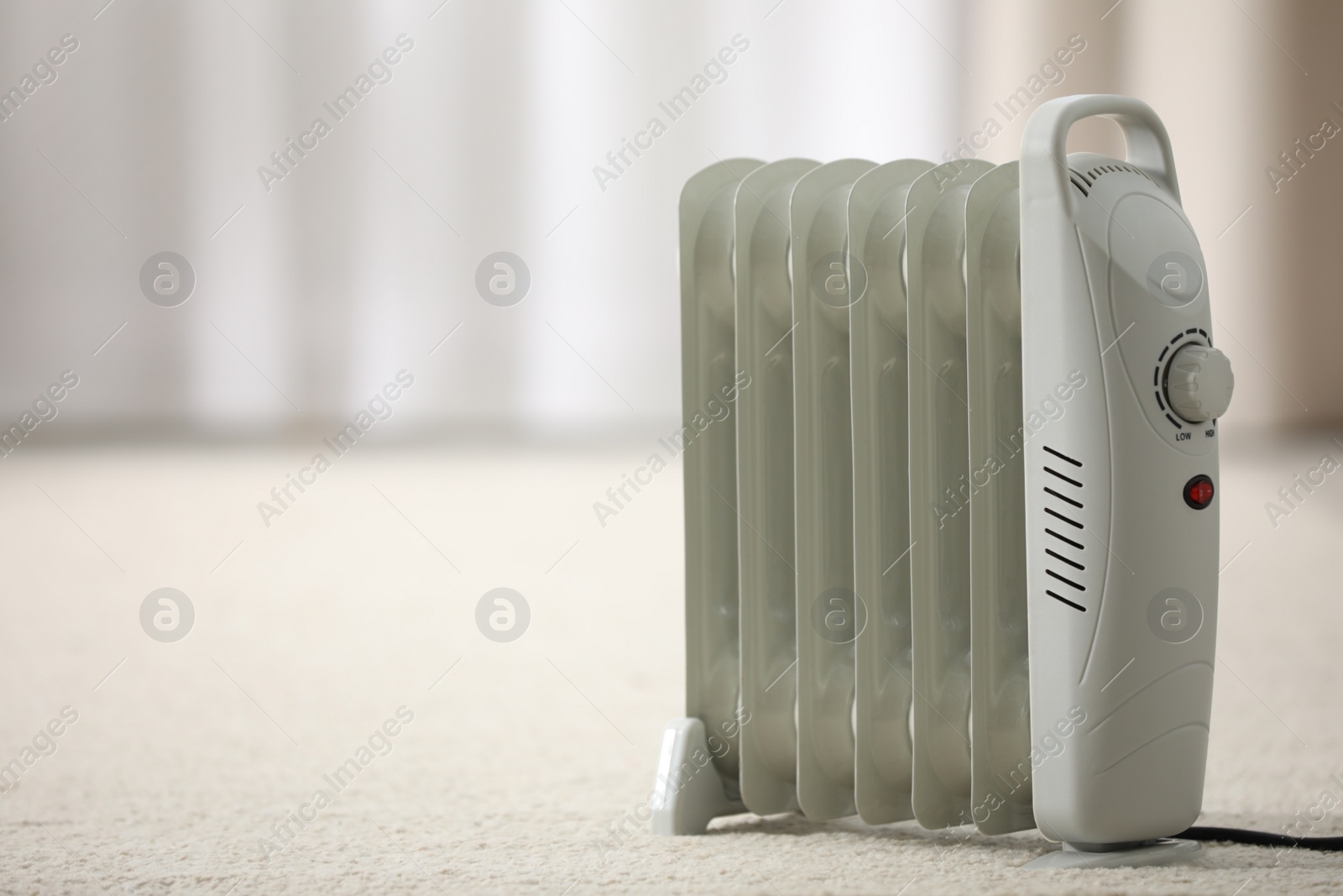 Photo of Modern electric heater on floor at home. Space for text