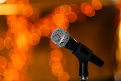 Microphone against festive lights, space for text. Musical equipment