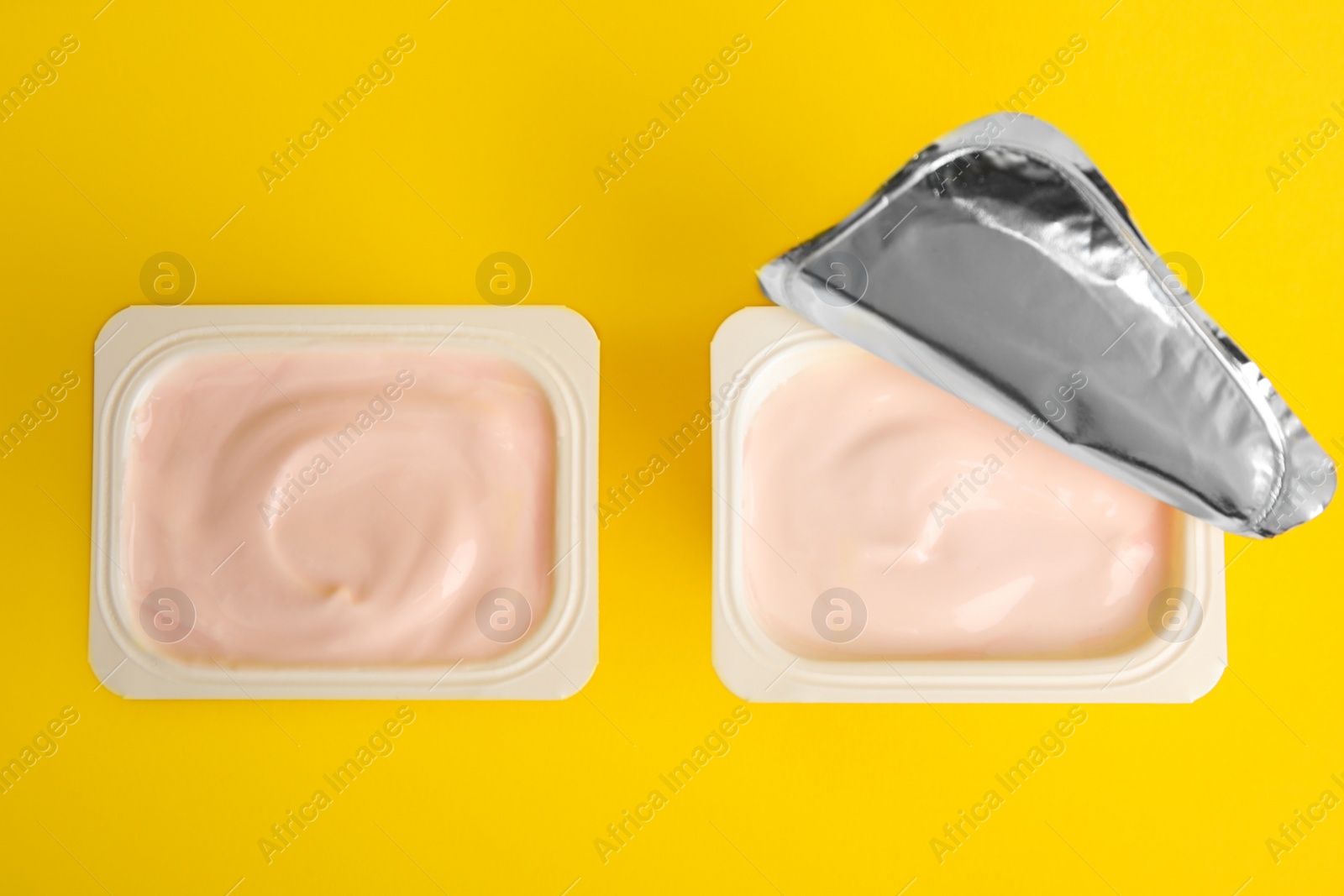 Photo of Tasty organic yogurt on yellow background, flat lay